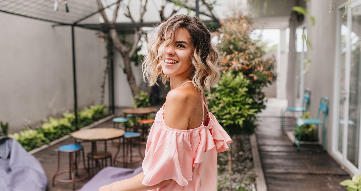 Garota com o corte de cabelo curto ondulado chamado de long bob ou lob